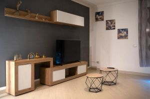 Soggiorno semplice con una TV, arredi in legno e alcuni oggetti decorativi.