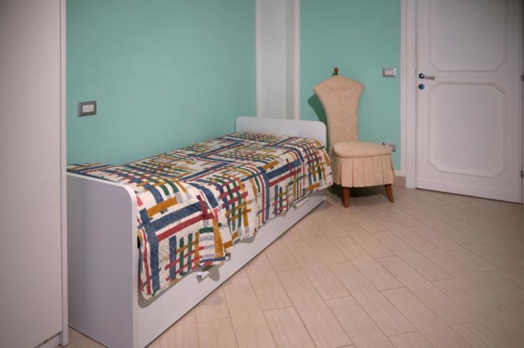 Camera confortevole e ben arredata, dotata di un letto matrimoniale e una poltrona, perfetta per momenti di relax.