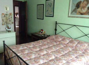 Camera confortevole e serena, con alcuni elementi decorativi e accesso a zone condivise.