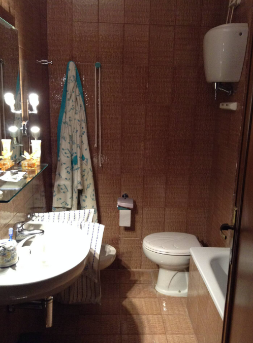 Bagno di un appartamento con sanitari e specchio, spazi ordinati e ambiente confortevole.