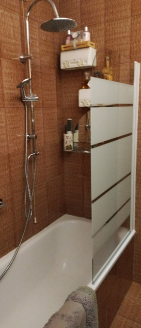 Doccia contemporanea con piastrelle scure e parete in vetro, semplice e funzionale per un bagno moderno.
