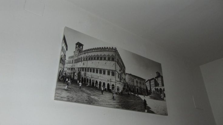 Scène en noir et blanc d'un palais historique entouré d'une place fréquentée.