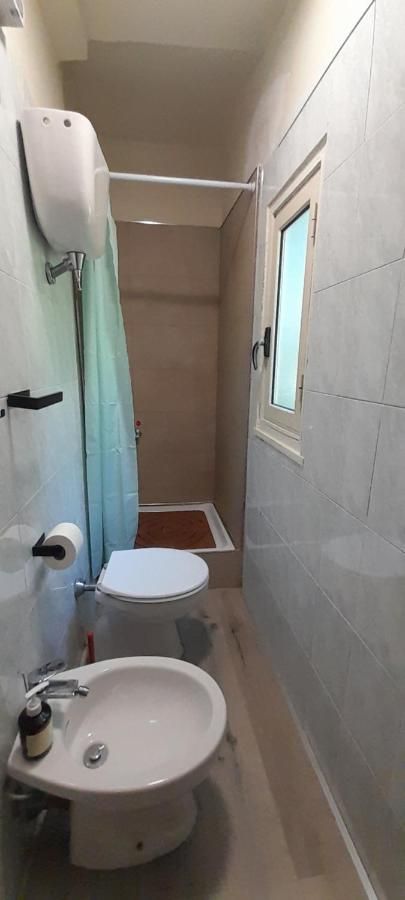 Une salle de bain moderne et lumineuse avec douche et toilettes, située dans un environnement soigné et sobre.