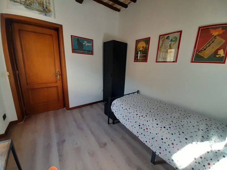 Chambre simple et bien aménagée avec un lit simple, située dans un environnement lumineux et confortable.