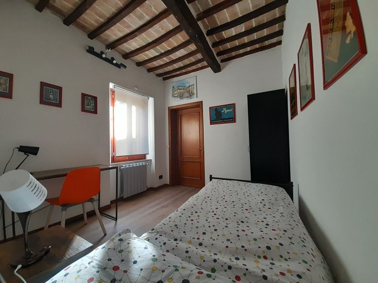 Une chambre simple avec des plafonds hauts et une décoration contemporaine. Parfaite pour un séjour relaxant.