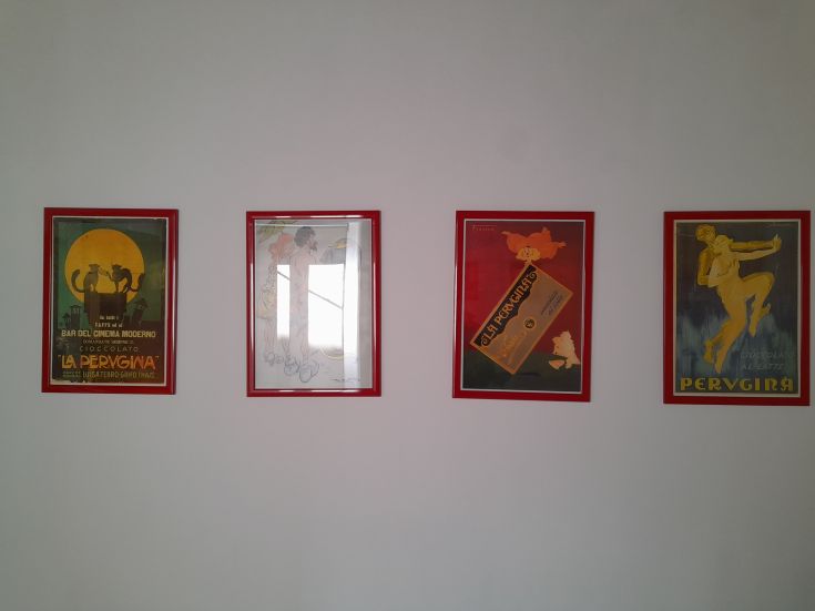 Deux cadres vintage sont accrochés à un mur, avec des finitions rouges, représentant de la publicité rétro.