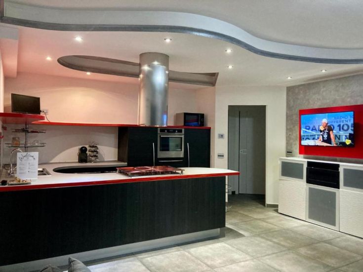 Ampio open space con cucina ben attrezzata, caratterizzato da dettagli semplici e funzionali. Illumina l'ambiente e favorisce la convivialità.