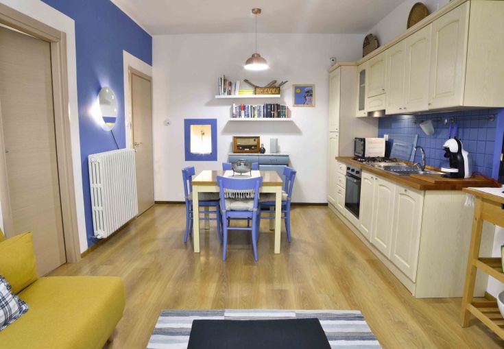 Cuisine moderne avec des murs bleus et des meubles clairs, atmosphère lumineuse et accueillante.