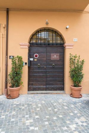 Porte d'entrée simple avec des plantes décoratives de chaque côté, située dans un quartier résidentiel.