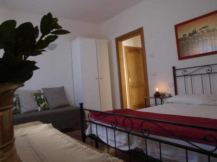 Bequemes Zimmer mit Doppelbett und Sitzbereich, perfekt für einen ruhigen Aufenthalt.