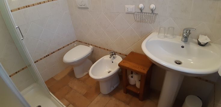 Funktionales und komfortables Badezimmer mit Dusche, Bidet und Waschbecken in einem Bauernhof. Ideal für eine entspannende Pause.