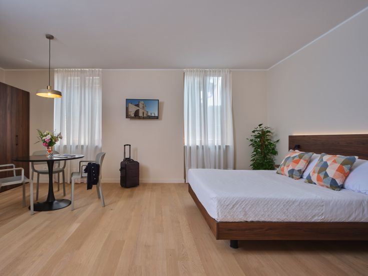 La stanza si affaccia sulla storica Via Portica, offrendo una vista suggestiva sulla Piazza del Comune di Assisi e sulla maestosa cupola della Cattedrale di San Rufino.