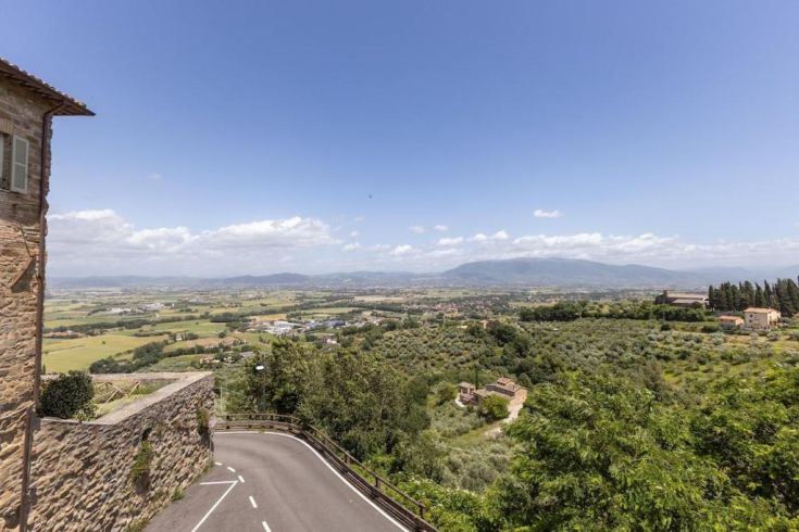 A scene from a road winding through green hills and typical olive groves of the Umbrian countryside.