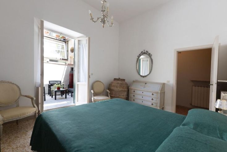 A spacious and bright room with simple decor and access to a terrace for relaxation.