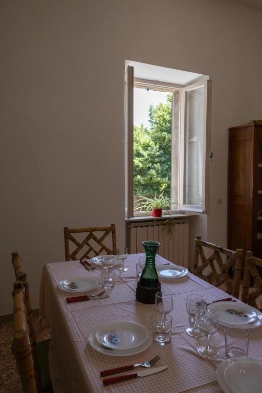 A set dining table in a bright kitchen, overlooking a well-kept garden.