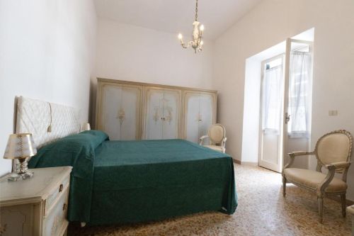 Camera spaziosa e ben illuminata, arredata con mobili tradizionali e dettagli sobrii.