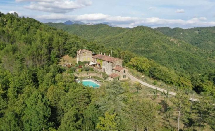 A villa surrounded by vast natural landscapes, featuring a pool and overlooking the hills.