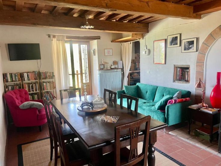 A simple living room with brightly colored furniture and a well-stocked bookshelf.