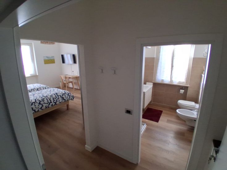 Interior of a cozy apartment featuring a bedroom and a bathroom, furnished practically.