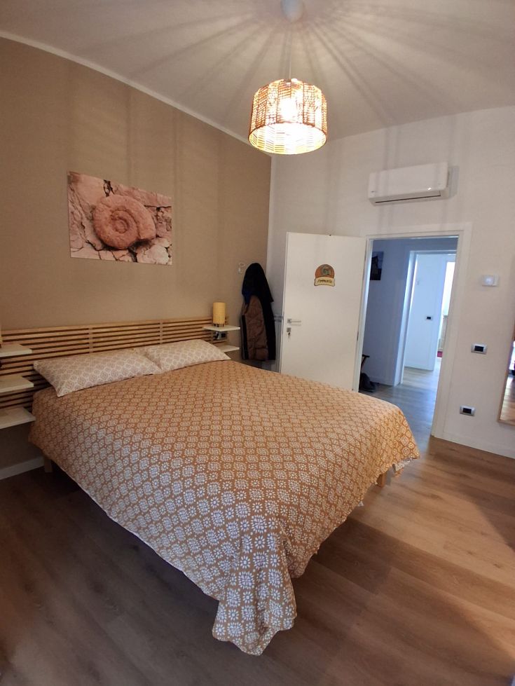 A simple bedroom with a double bed. Essential furnishings and good lighting.