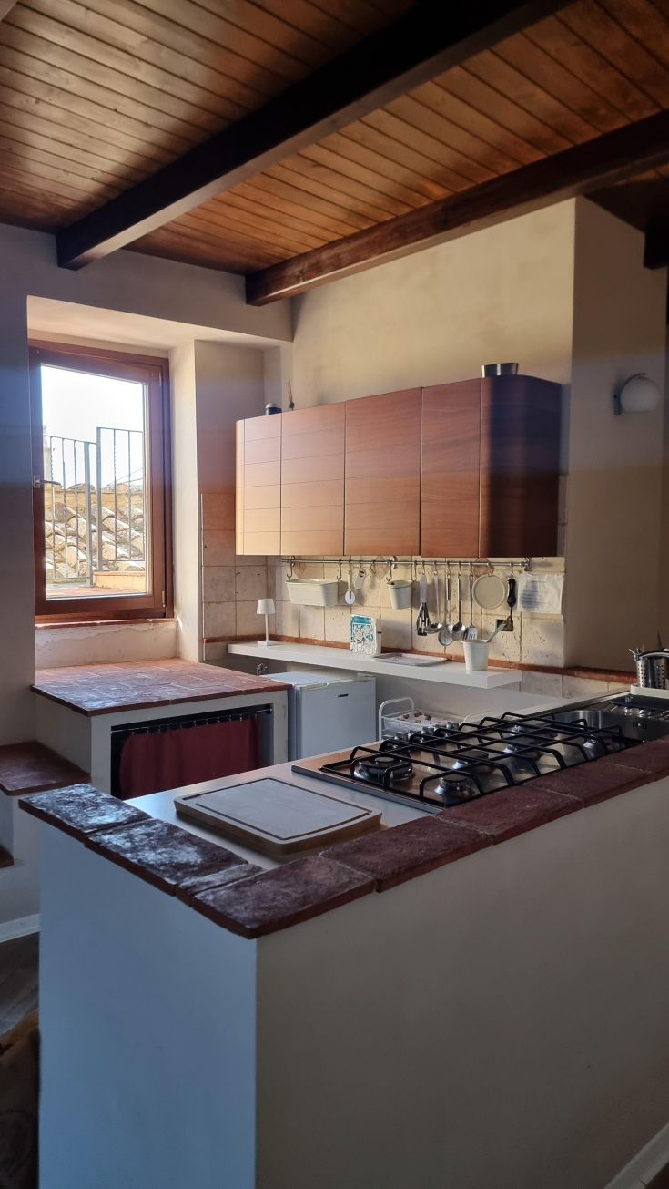 Bright kitchen with wooden details in a historic building. Cozy and warm atmosphere.