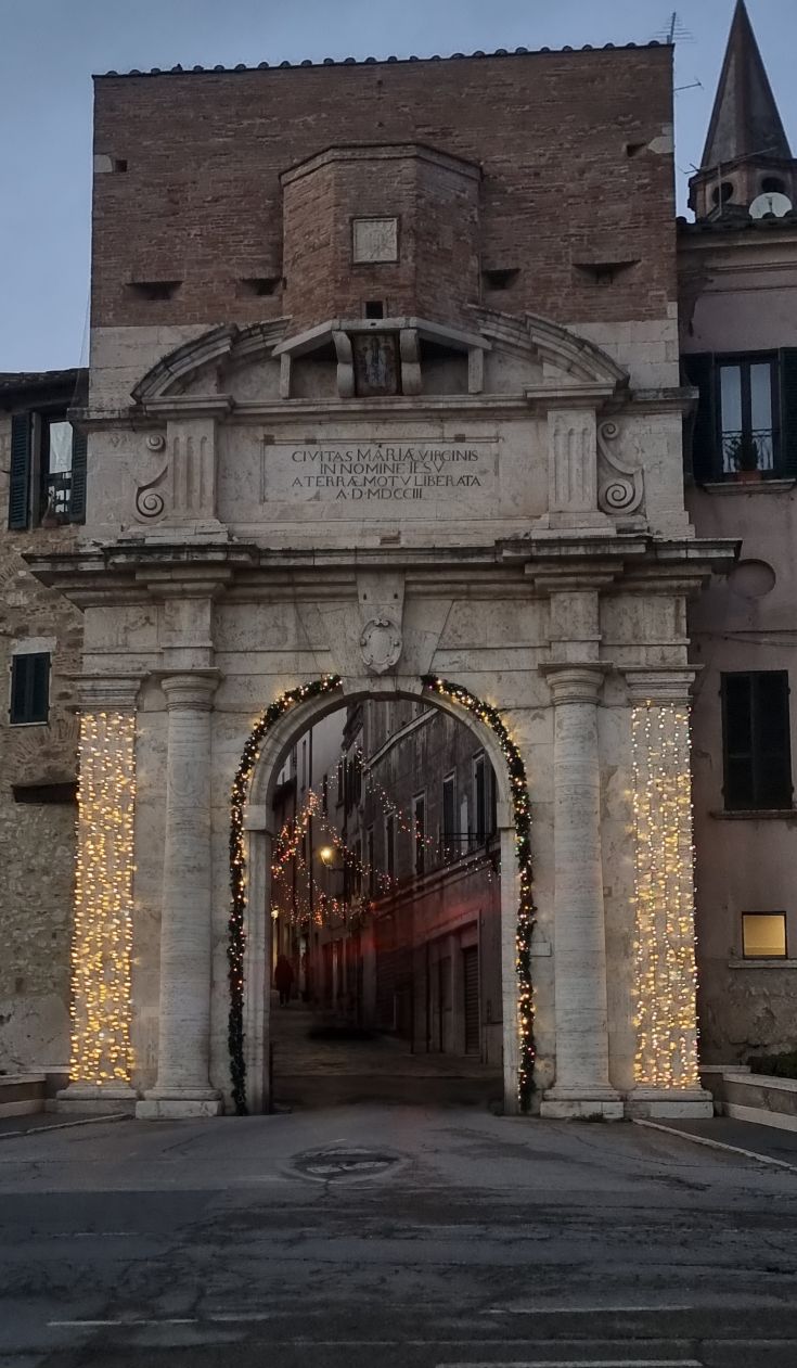 An ancient arch, decorated for an occasion, is located in the historic center of Amelia.