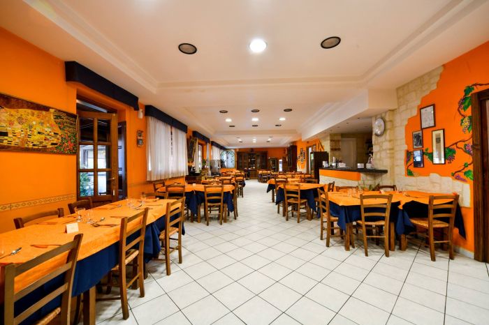 interno del ristorante, sala con pareti arancioni con tavoloi apparecchiati 