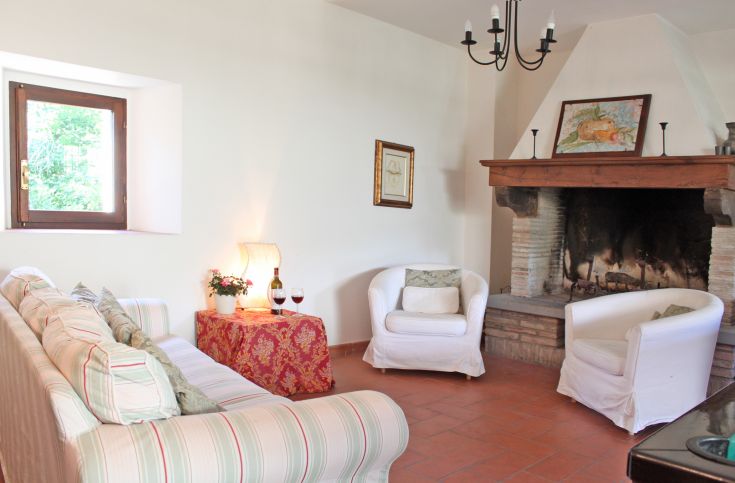 A cozy living room with a sofa and a fireplace, perfect for relaxing moments. Warm and inviting atmosphere.