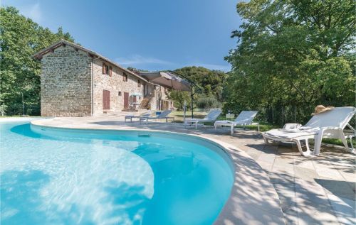 A renovated building with a pool, surrounded by olive trees, perfect for relaxation and cultural explorations in Umbria.