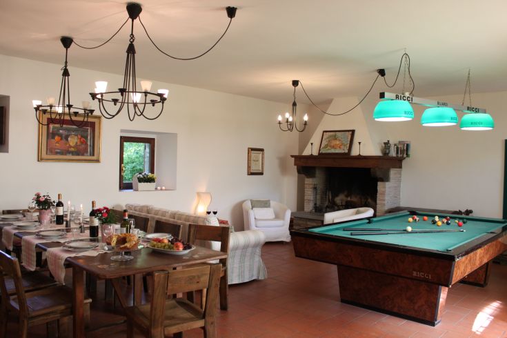 Cozy environment with a dining table, pool table, and fireplace, perfect for relaxation.