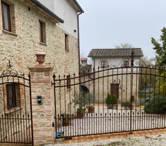 Stone building with a decorated gate, located in a serene and natural setting.
