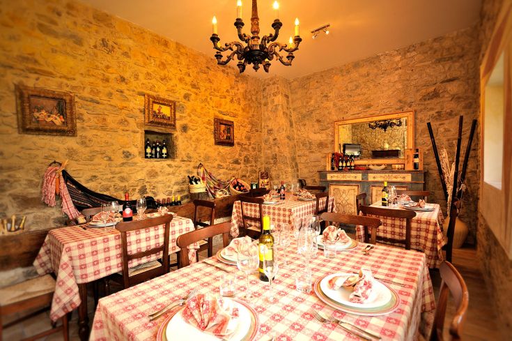 Un ristorante tipico dell'Umbria con tavoli curati e pareti in pietra, che offre un'atmosfera accogliente.