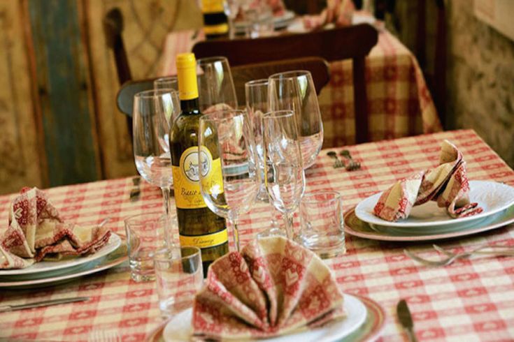 Tavola apparecchiata con cura in un agriturismo, ideale per una cena in compagnia.