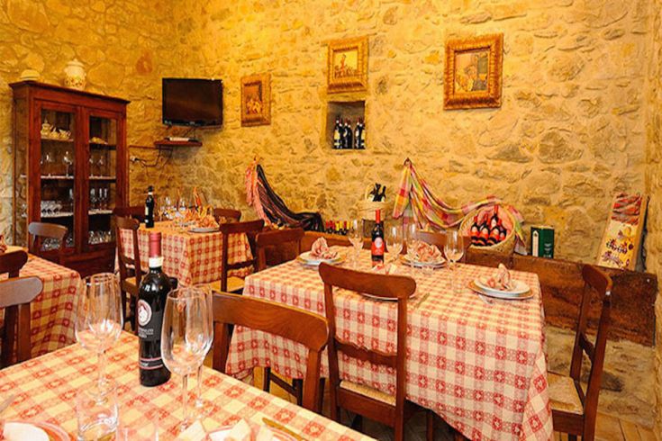 Interno di un ristorante con tavoli sistemati e decorazioni in stile rustico.