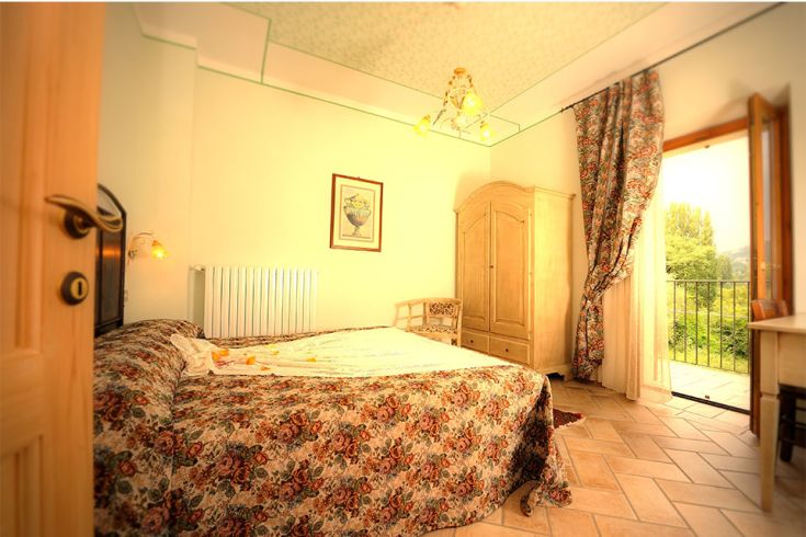 Camera semplice con panorama su un paesaggio verde, ideale per un soggiorno rilassante.