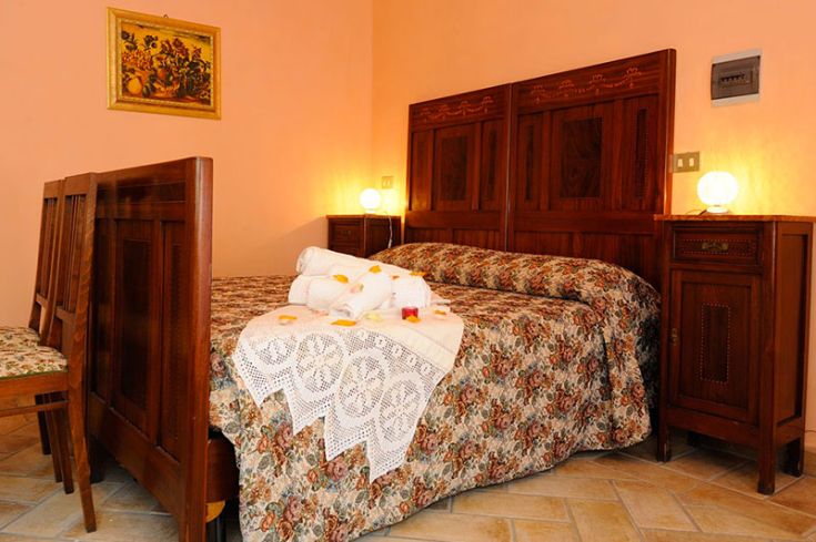 Camera semplice con arredamento in legno e decorazioni fiorite, perfetta per un soggiorno tranquillo.