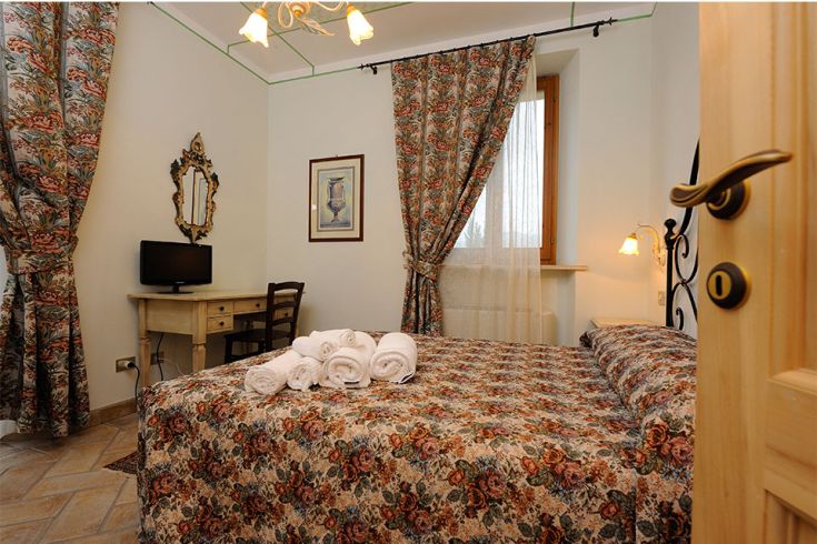 Un'accogliente camera in agriturismo, con decorazioni floreali e un'atmosfera tranquilla.