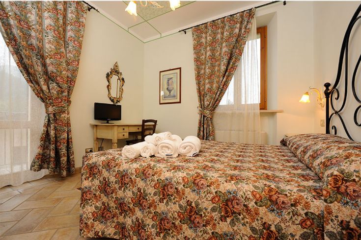 Camera accogliente in agriturismo, con decorazioni semplici e buona illuminazione naturale.