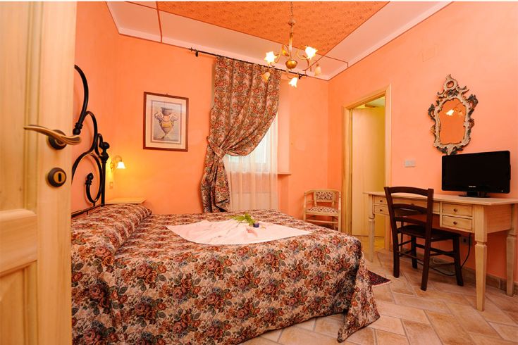 Camera accogliente con elementi tradizionali e colori caldi, adatta per un soggiorno tranquillo.