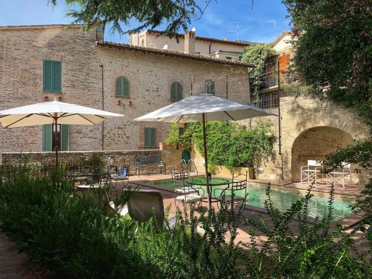 A view of the garden with a swimming pool located in a peaceful village in Umbria.