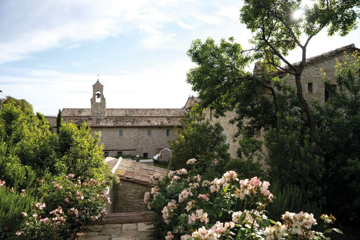 A historical building located in Umbria, surrounded by well-maintained gardens and featuring modern architectural elements.