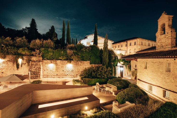 In the heart of Umbria, a palace blending historical and modern elements, surrounded by a serene landscape.