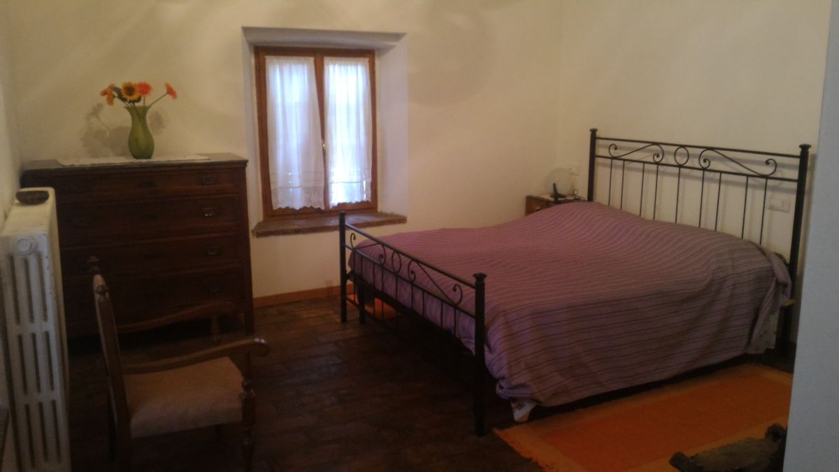 Camera confortevole con letto matrimoniale, armadio e piante ornamentali.