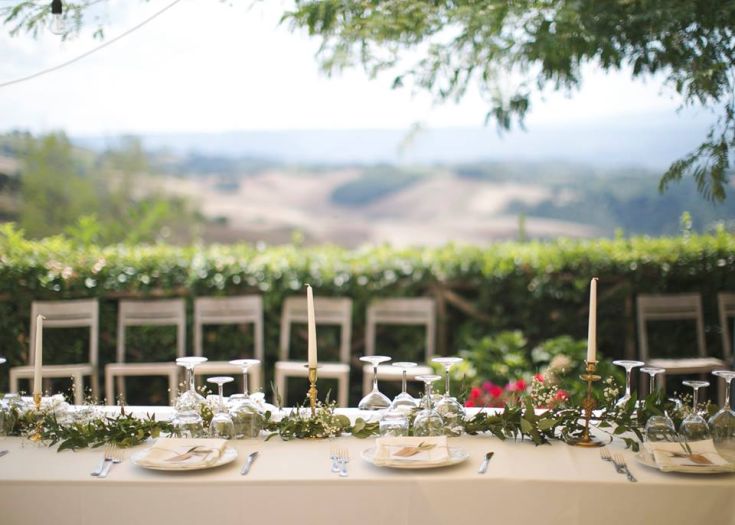 Une table décorée à l'extérieur, entourée de plantes et de fleurs.