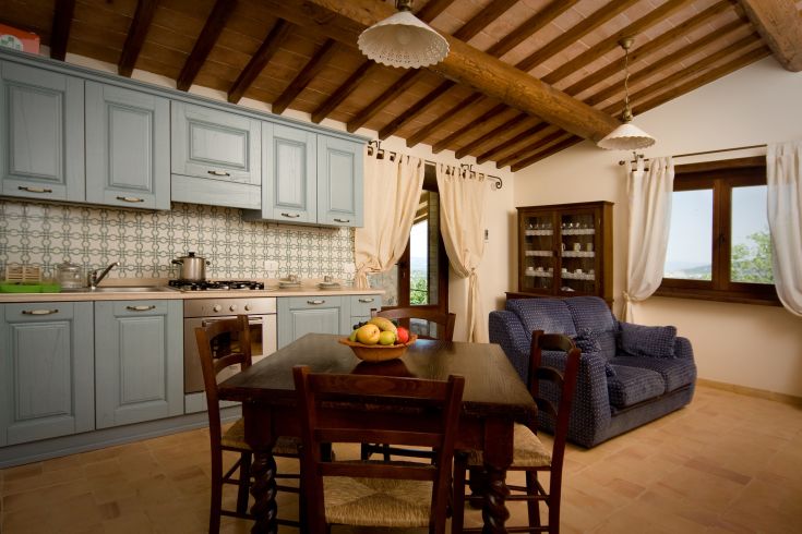 Cuisine accueillante dans un bâtiment rénové, avec vue sur la vallée et des détails soigneusement travaillés.