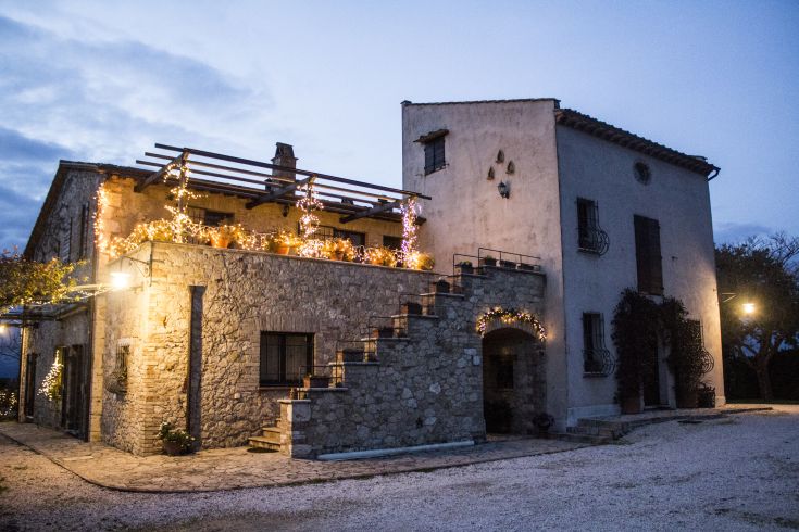 Un agritourisme entouré de nature, décoré avec des lumières de Noël créant une atmosphère accueillante.