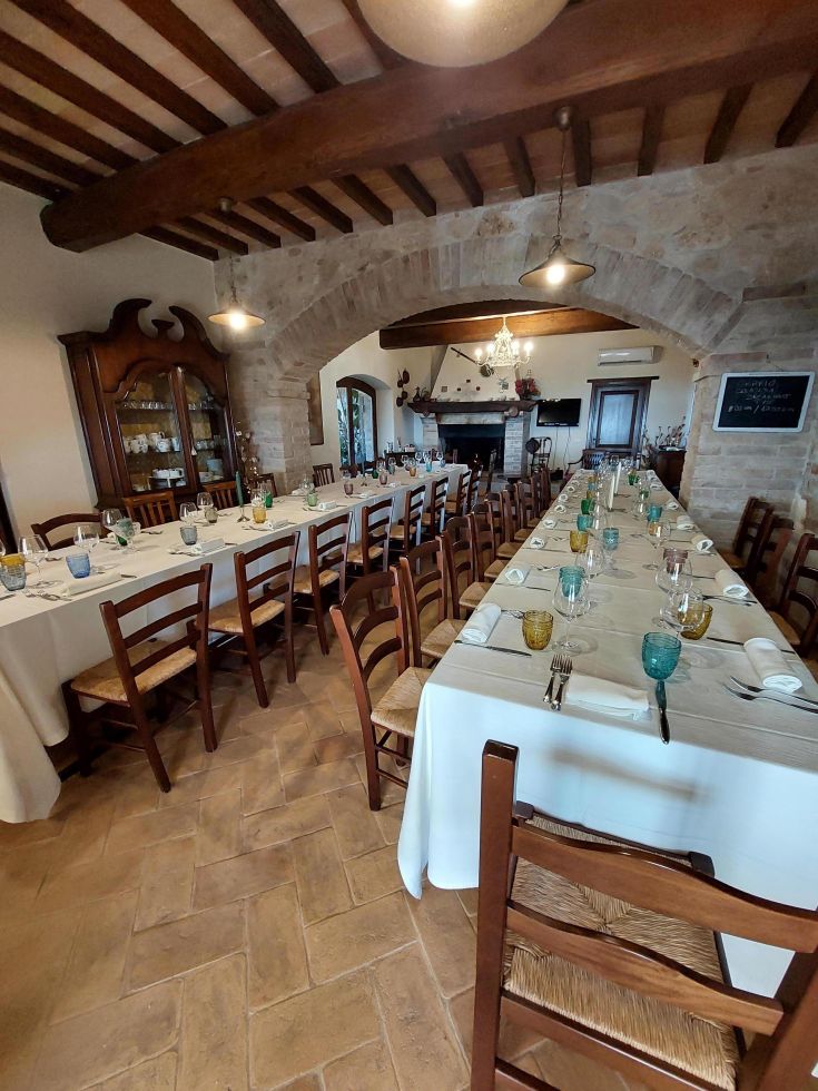 L'intérieur d'un agriturisme confortable, avec des tables prêtes à accueillir les invités dans une ambiance détendue.