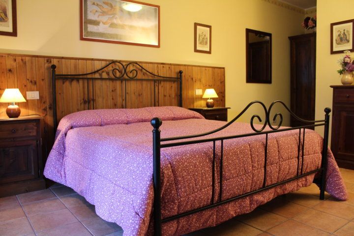 Chambre spacieuse et confortable avec un lit double et des meubles de style rustique.