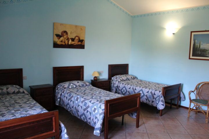 Chambre simple avec lits jumeaux et meubles en bois, idéale pour un séjour paisible.