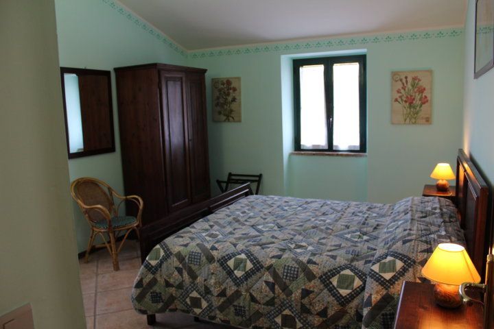 Chambre dans un agriturisme en Ombrie, avec un lit double. Décor simple et tons doux.
